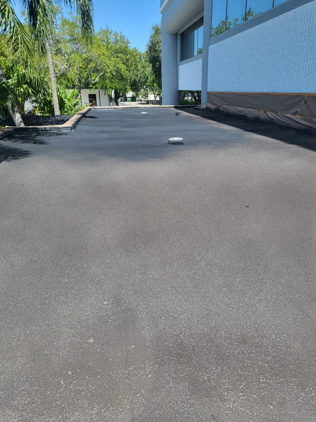 Coated flat roof with drains beside a commercial building