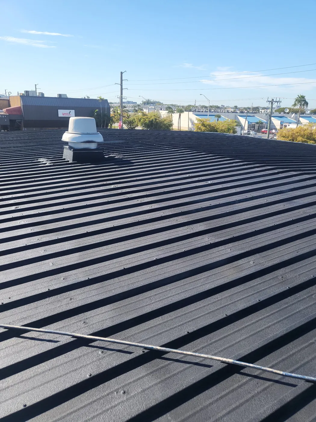 Coated commercial metal roof with a sealed rooftop vent