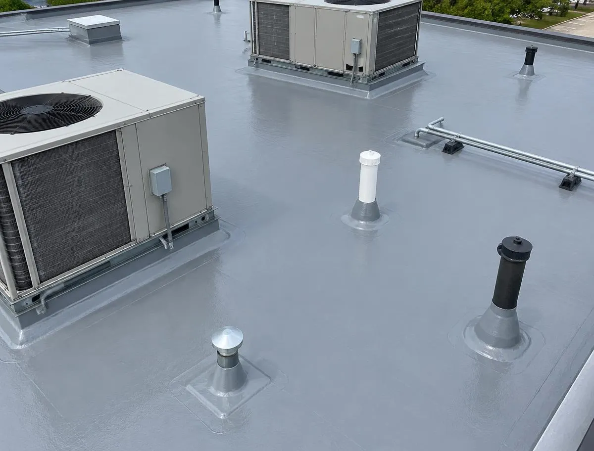 Commercial low-slope roof with sealed HVAC curbs and pipe penetrations
