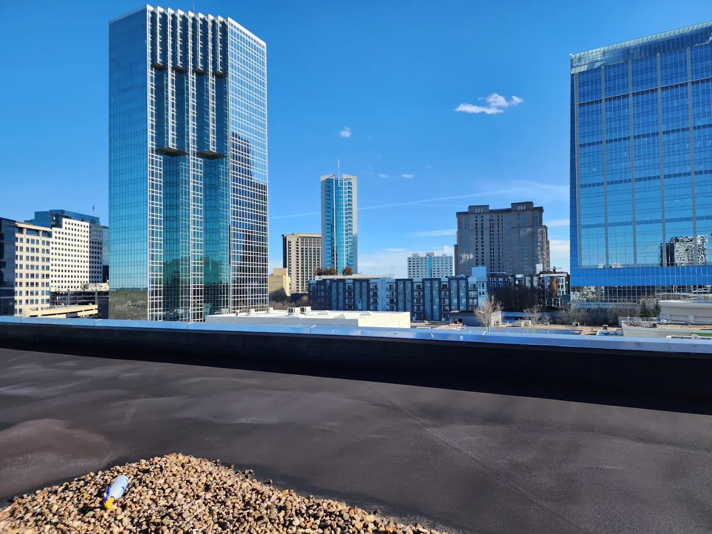 Finished black Wetsuit membrane on a high-rise gravel roof beside downtown towers