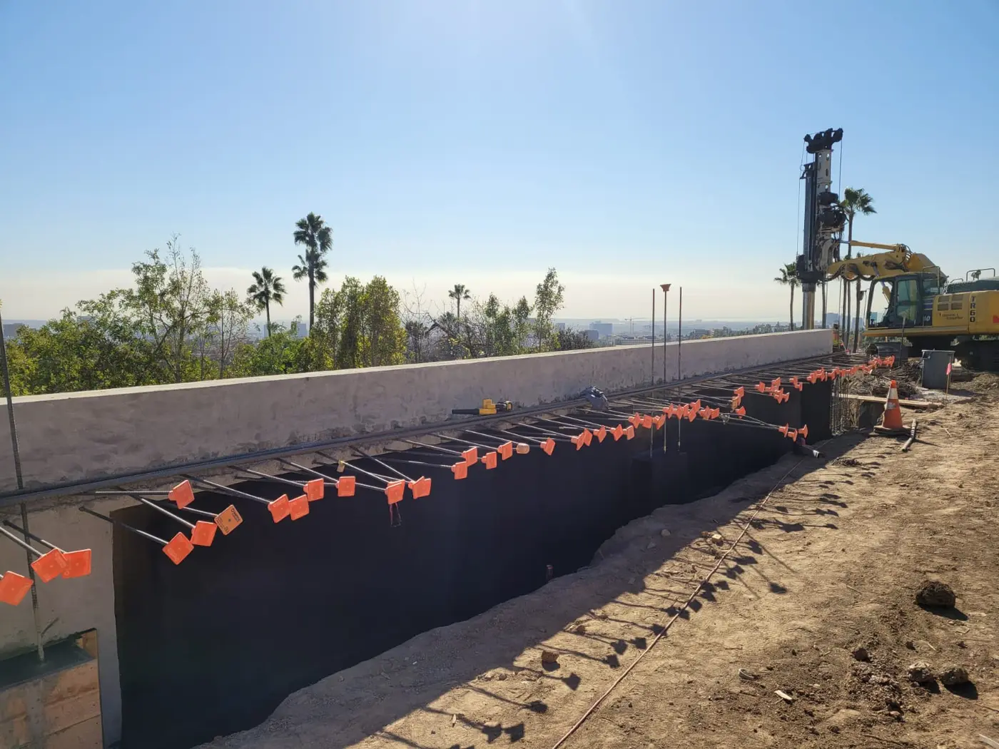 Long retaining wall sprayed with black Wetsuit membrane